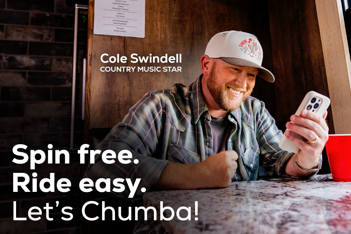 Chumba Casino email header: Cole Swindell smiling at his phone at a table. Spin free. Ride easy. Let’s Chumba!